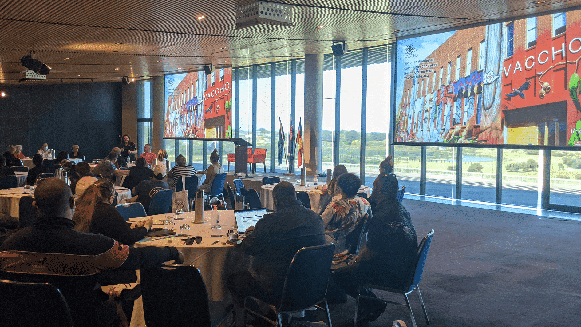 Staff from VACCHO's Member organisations gathered in a room watching a presentation being delivered by VACCHO CEO Jill Gallagher AO